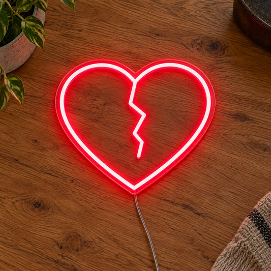 Broken Heart LED Neon Light Sign in red, featuring broken-heart outline on a wooden surface.