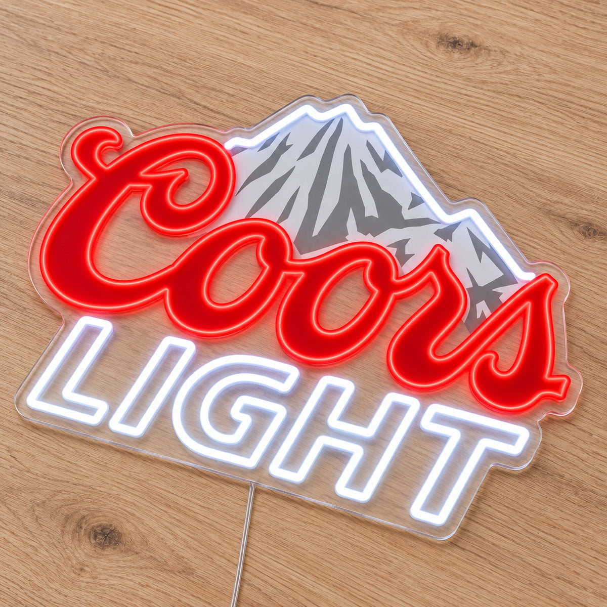 Coors Light LED Neon Sign, featuring illuminated beer-brand logo on a wooden surface.