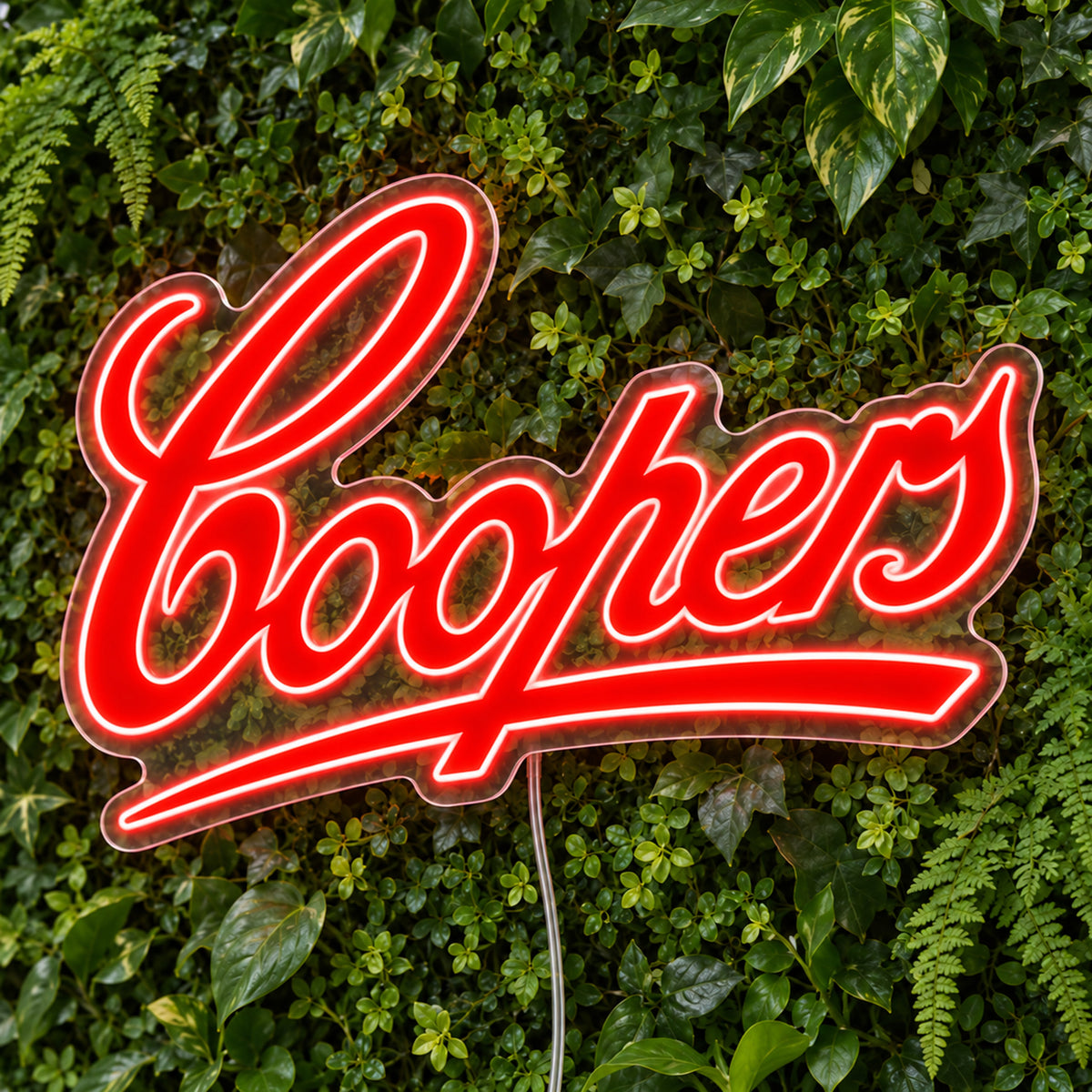 Coopers LED Neon Sign, featuring illuminated beer-brand logo on a green foliage wall.