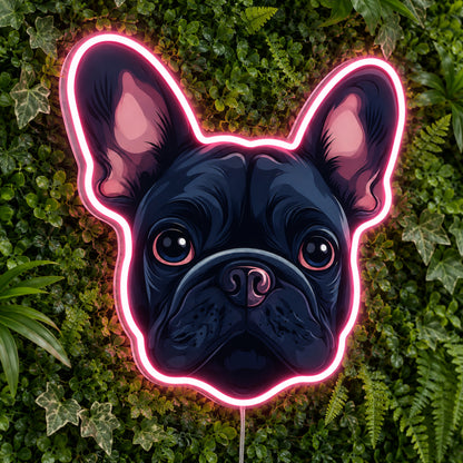 French Bulldog LED Neon Sign in pink, featuring a French bulldog face with a glowing outline against foliage.