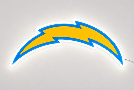 An illuminated LED neon sign of the Los Angeles Chargers lightning bolt logo, featuring a bright yellow center with a blue outline and a glowing white border, set against a neutral light gray background.