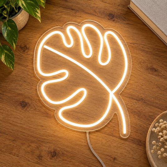 Leaf LED Neon Light Sign in warm white, featuring monstera-leaf outline on a wooden surface.