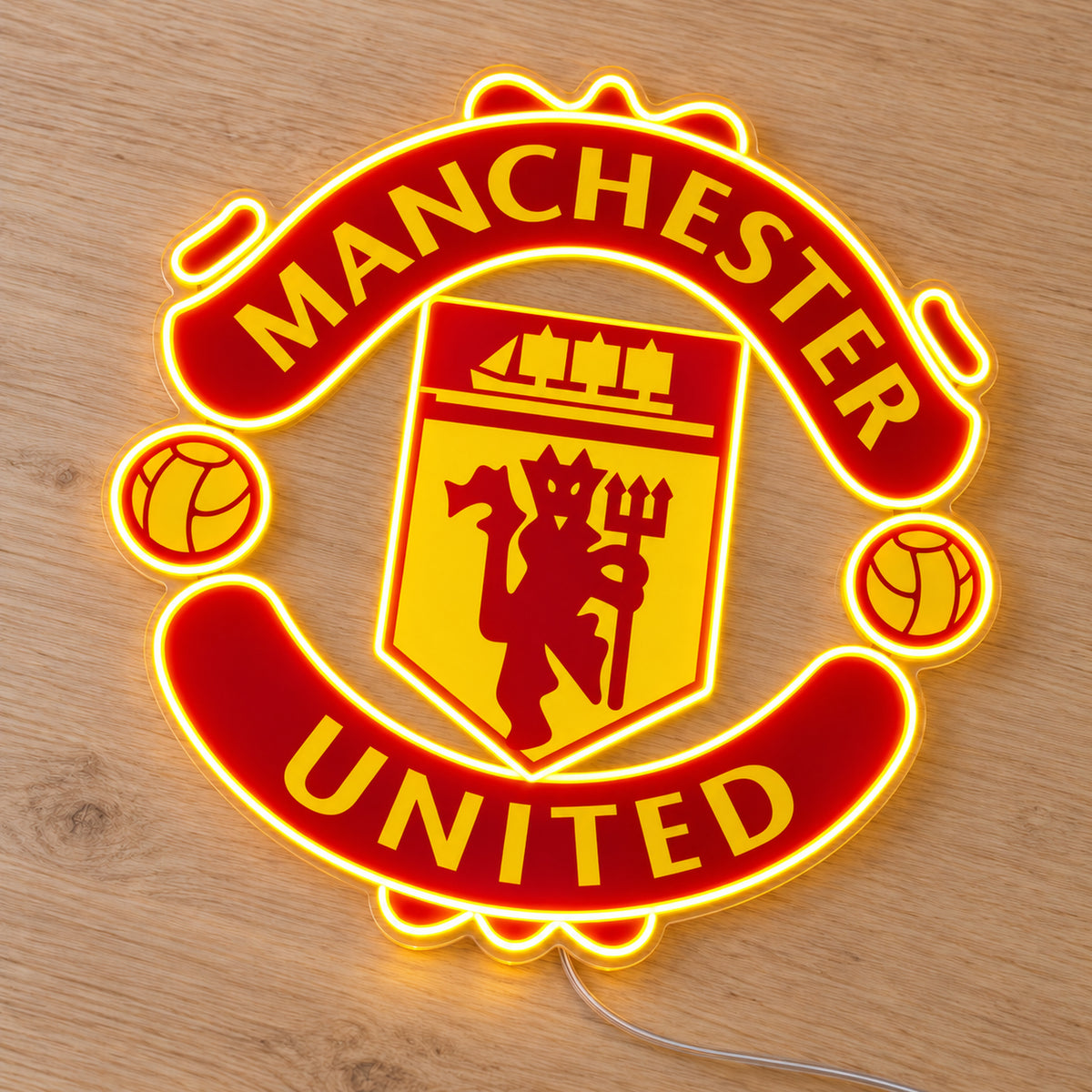 Manchester United LED Neon Sign, featuring team logo displayed on a wooden surface.