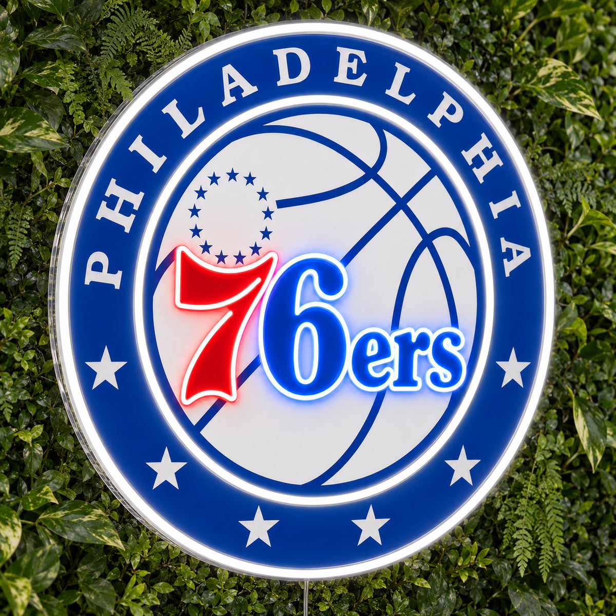 Philadelphia 76ers LED Neon Sign, featuring illuminated team logo on a green foliage wall.