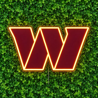 Washington Commanders LED Neon Sign, featuring illuminated team logo on a green foliage wall.