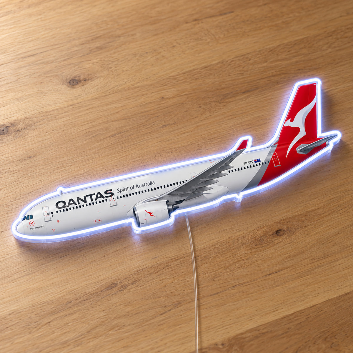 Airbus A330-300 Qantas Neon Sign with printed aircraft details and an illuminated LED outline on clear acrylic, shown on a wooden surface, registration VH-QPJ