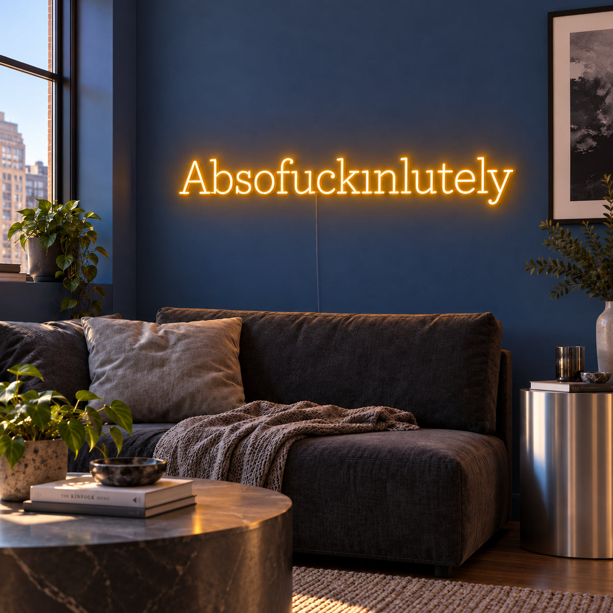Absofuckinlutely Neon Sign glowing gold above a charcoal sofa on a blue wall.