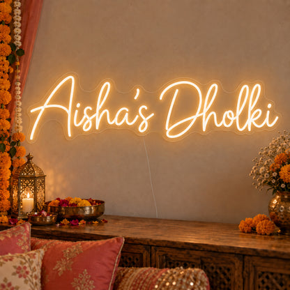 Personalised Dholki Neon Sign on clear cut-to-shape acrylic, illuminated on a wall in a styled celebration setting; sample personalised wording shown