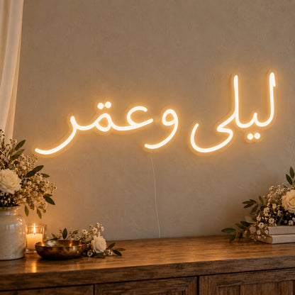 Personalised Arabic Couple Names Neon Sign on clear cut-to-shape acrylic in an illuminated wall display; example personalisation shown.