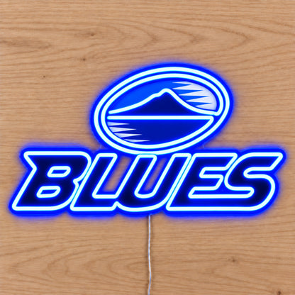 Blues neon sign with blue LED neon on a light wooden surface, overhead view