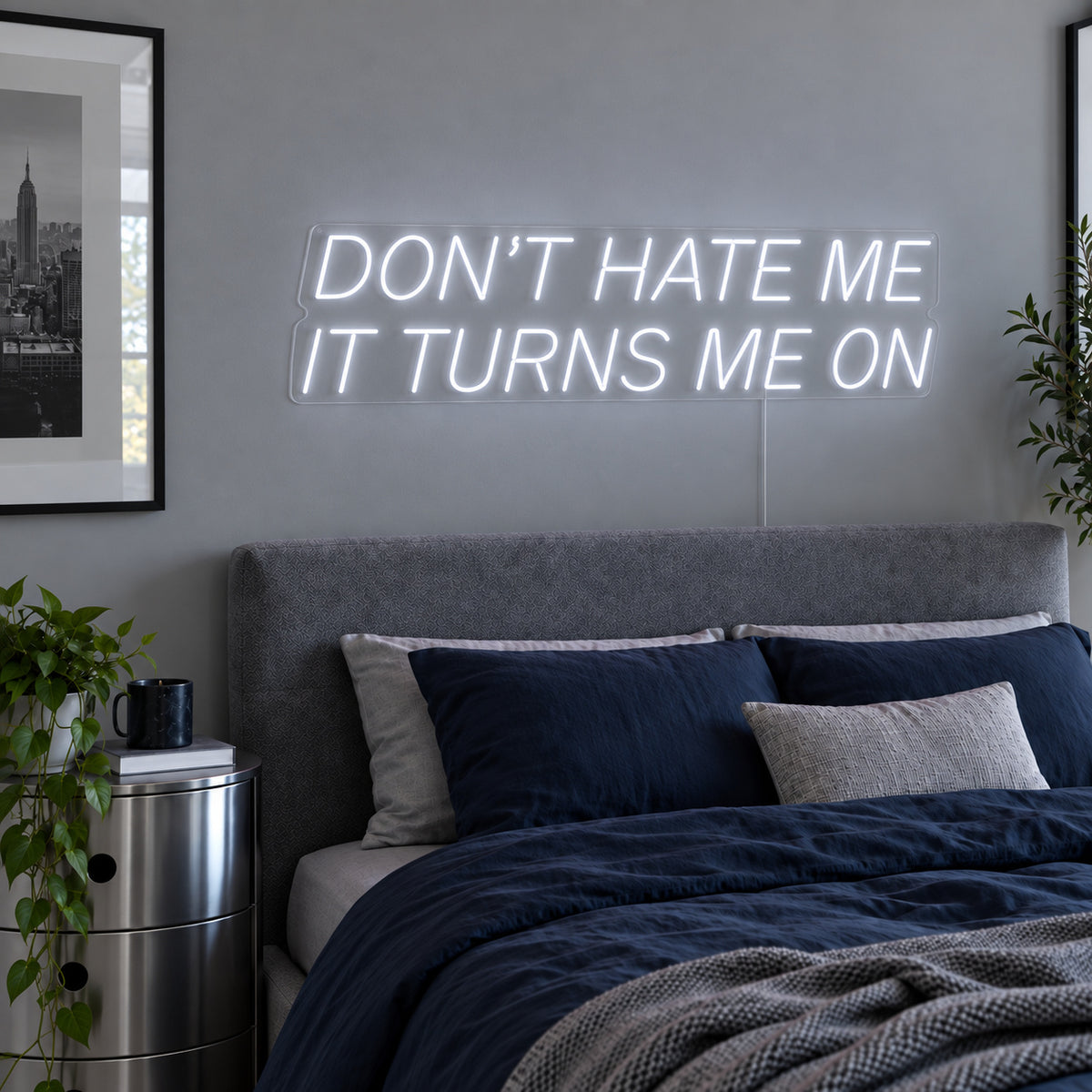 Don't Hate Me It Turns Me On Neon Sign, RGB colour-changing option shown in white above a bed with dark blue bedding.