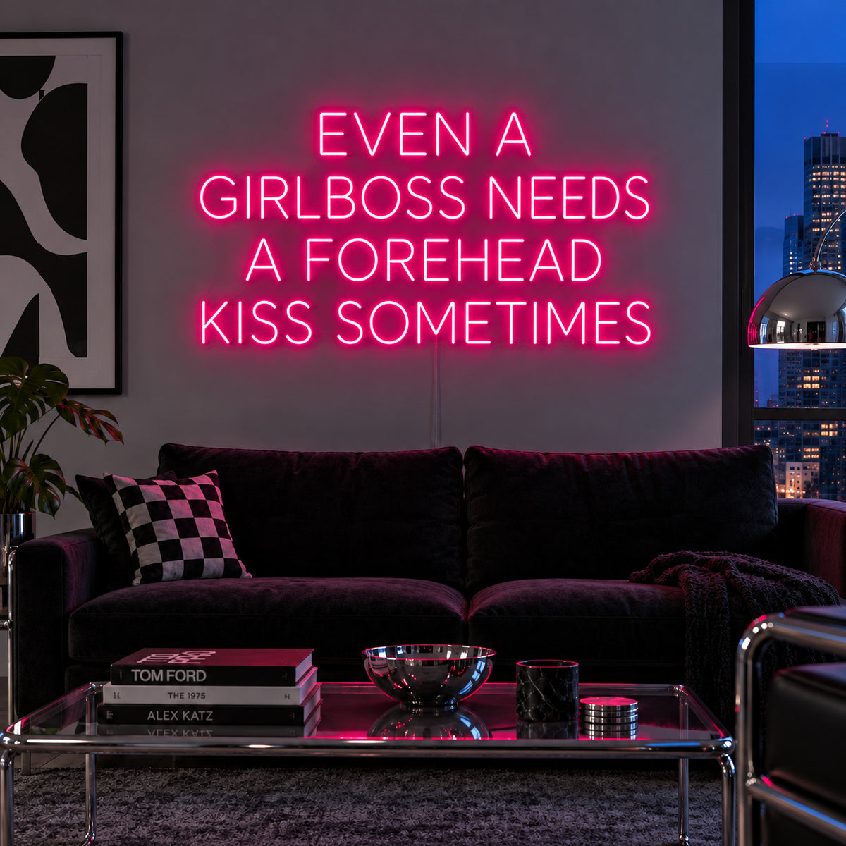 Rose Red version of the Even A Girlboss Needs A Forehead Kiss Sometimes Neon Sign, shown above a dark sofa and mirrored coffee table.