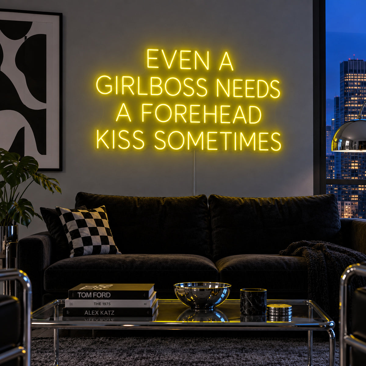 Even A Girlboss Needs A Forehead Kiss Sometimes Neon Sign with yellow lighting, displayed above a dark sofa and mirrored coffee table.