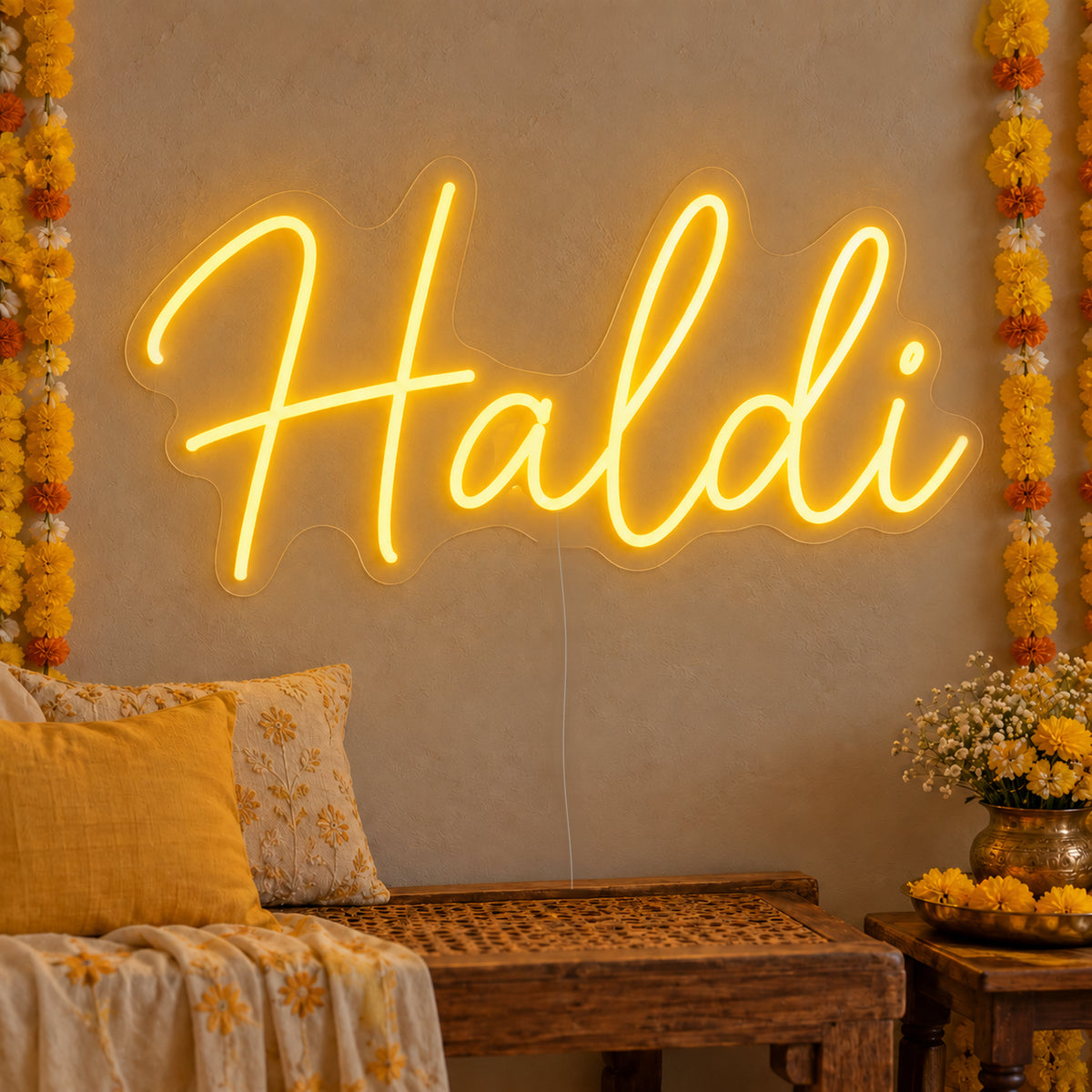 Haldi Neon Sign on clear cut-to-shape acrylic, illuminated on a wall in a styled celebration setting