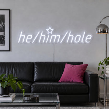 He/Him/Hole Neon Sign, RGB colour-changing option shown in white above a black leather sofa.