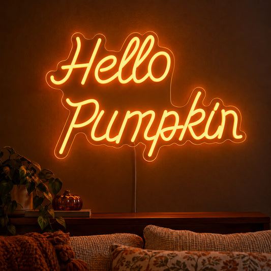 Hello Pumpkin Orange Neon Sign featuring Hello Pumpkin wording in flowing orange script over two lines, displayed on a dark wall above a wooden sideboard.
