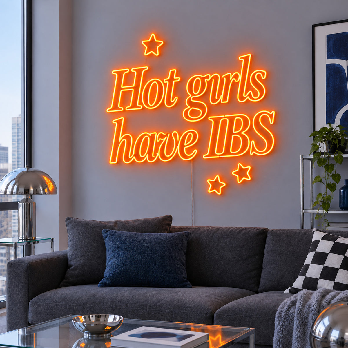 Orange version of the Hot Girls Have IBS Neon Sign, shown with star details above a charcoal sofa.