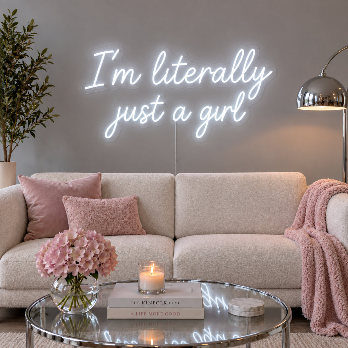 I'm Literally Just A Girl Neon Sign glowing white above a cream sofa.