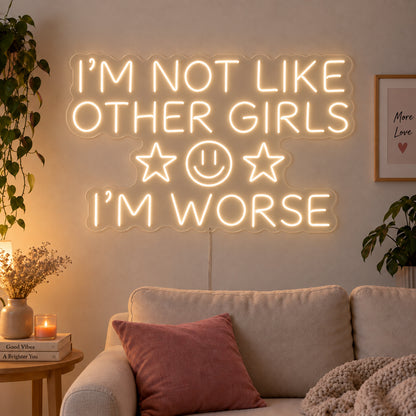 Warm White version of the I'm Not Like Other Girls I'm Worse Neon Sign, shown with stars and a smiley face above a cream sofa.