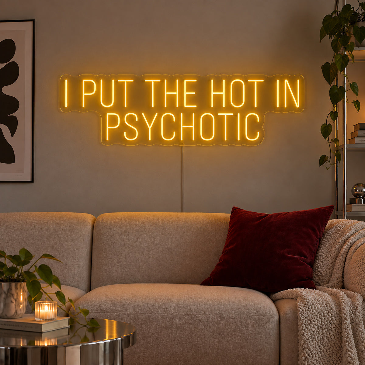 I Put The Hot In Psychotic Neon Sign glowing gold above a neutral sofa.
