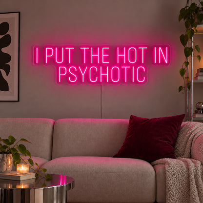 Rose Red version of the I Put The Hot In Psychotic Neon Sign, shown above a neutral sofa.