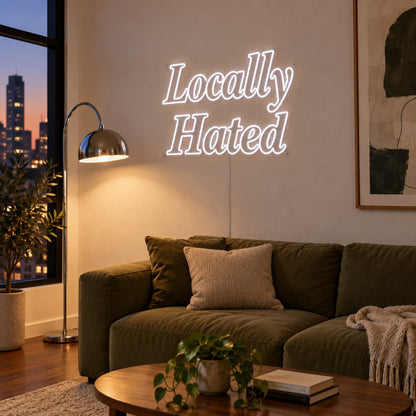 Locally Hated Neon Sign, RGB colour-changing option shown in white above a green sofa.