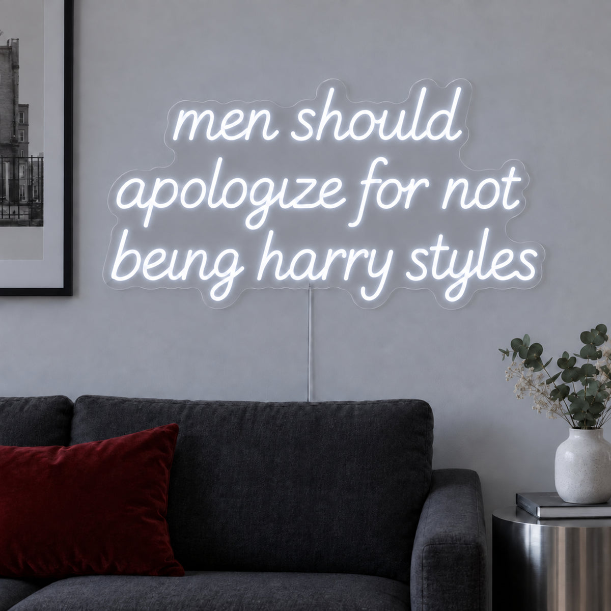 Men Should Apologize For Not Being Harry Styles Neon Sign, RGB colour-changing option shown in white above a dark sofa.