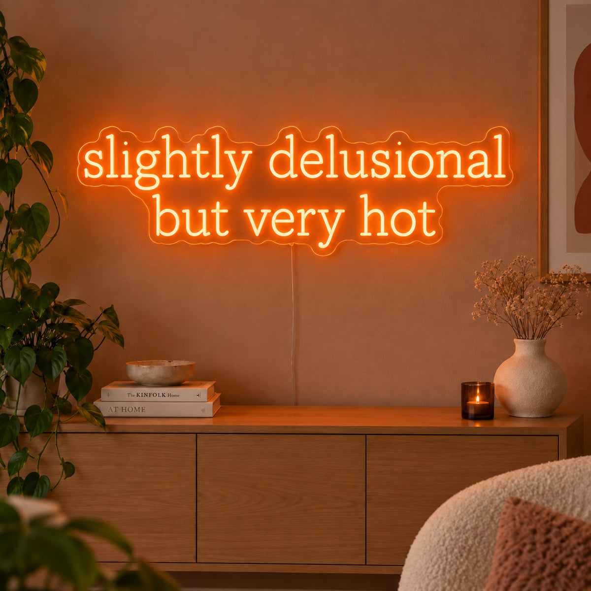 Orange version of the Slightly Delusional But Very Hot Neon Sign, shown above a wooden sideboard.