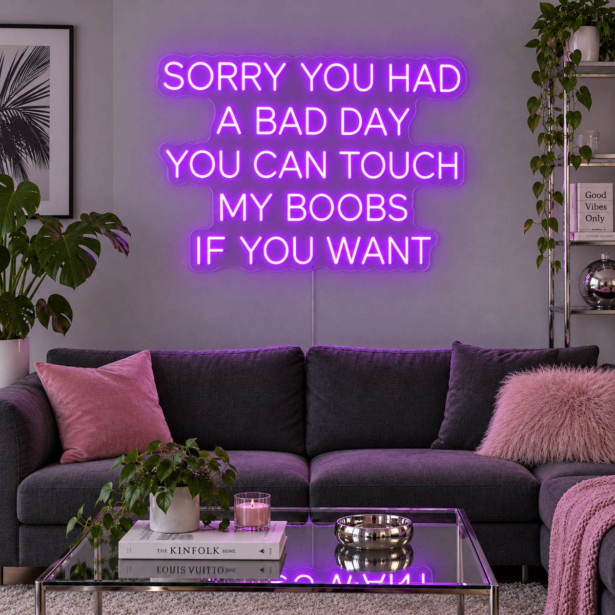 Sorry You Had A Bad Day You Can Touch My Boobs If You Want Neon Sign with purple lighting, displayed above a grey sofa with pink cushions.