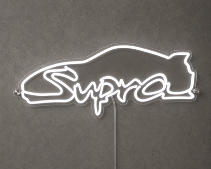 Supra Toyota inspired LED neon sign with white script lettering and car outline on a concrete wall