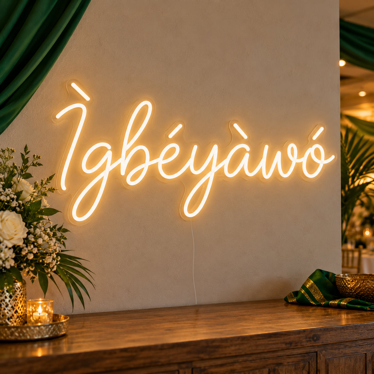 Ìgbéyàwó Yoruba Wedding Neon Sign on clear cut-to-shape acrylic, illuminated on a wall in a styled celebration setting